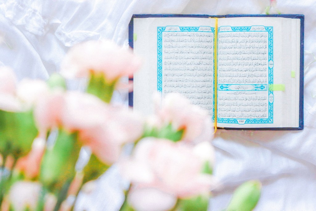 The Qur'an on a table with flowers.