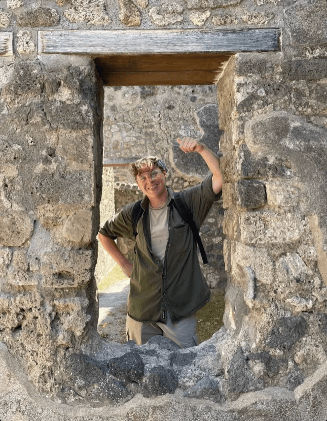 Research assistant Zea Jones stands in the window of ancient ruins.